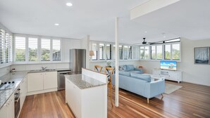 Een moderne, open woonruimte met keuken, eethoek en zithoek.