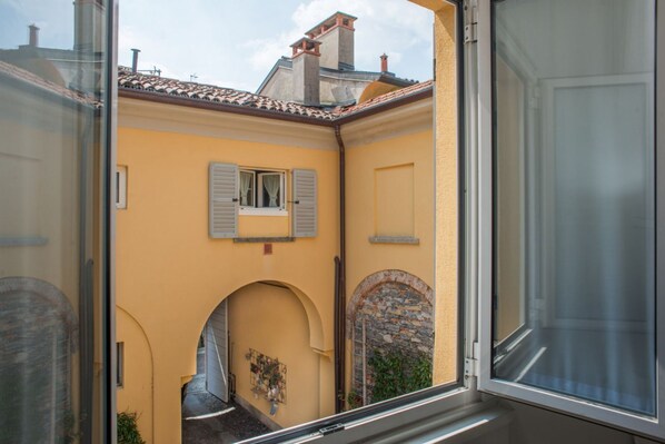 A yellow building with a window and a stone archway.