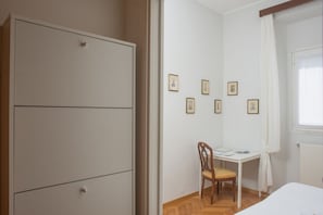 Makuuhuoneessa on vaatekaappi, työpöytä, tuoli ja seinällä on kehystettyjä kuvia.