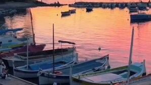A marina with boats docked during sunset.