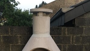 Un horno para pizza de piedra, con superficie de cocción plana y chimenea.