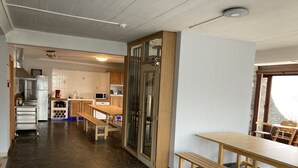 Una cocina con suelo de piedra, armarios de madera y una zona de comedor con bancos.