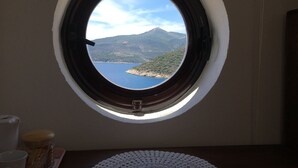 A round window with a view of a lake and mountains. - Luxury Villa, Private Pool, Beautiful Gardens, Stunning Sea & Mountain Views (Kalkan)