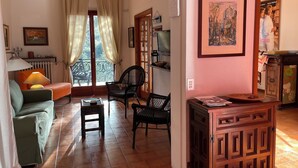 Una sala de estar acogedora con un sofá, sillones, una mesa y un aparador de madera.