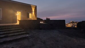 A modern building with a well-lit entrance and steps leading up to it. - House in the countryside with wonderful views Asinara Gulf and Castelsardo (Castelsardo)