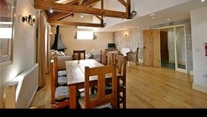 Ein Essbereich mit Holztisch und -stühlen, einem Kamin und einer Steinwand.