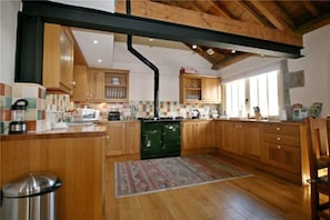 A kitchen with wooden cabinets, a central island, and a black stove.