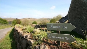 Ein Wegweiser zeigt in verschiedene Richtungen zu 'Saddle Tor' und 'Chinkwell Tor'.