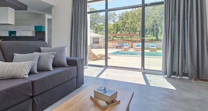 Moderni rauhallinen huvila suurella uima-altaalla vihreässä ympäristössä, joka tarjoaa yksityisyyttä