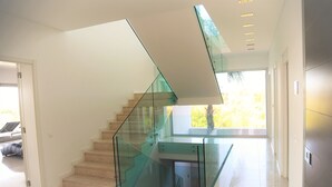 Una moderna scala con ringhiere in vetro e un angolo studio integrato.