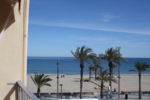 A beach view from a balcony with palm trees and a clear sky. -  TORREMAR APARTMENT IN FRONT OF THE SEA.  VT- 450557-A (ALICANTE/ALACANT)