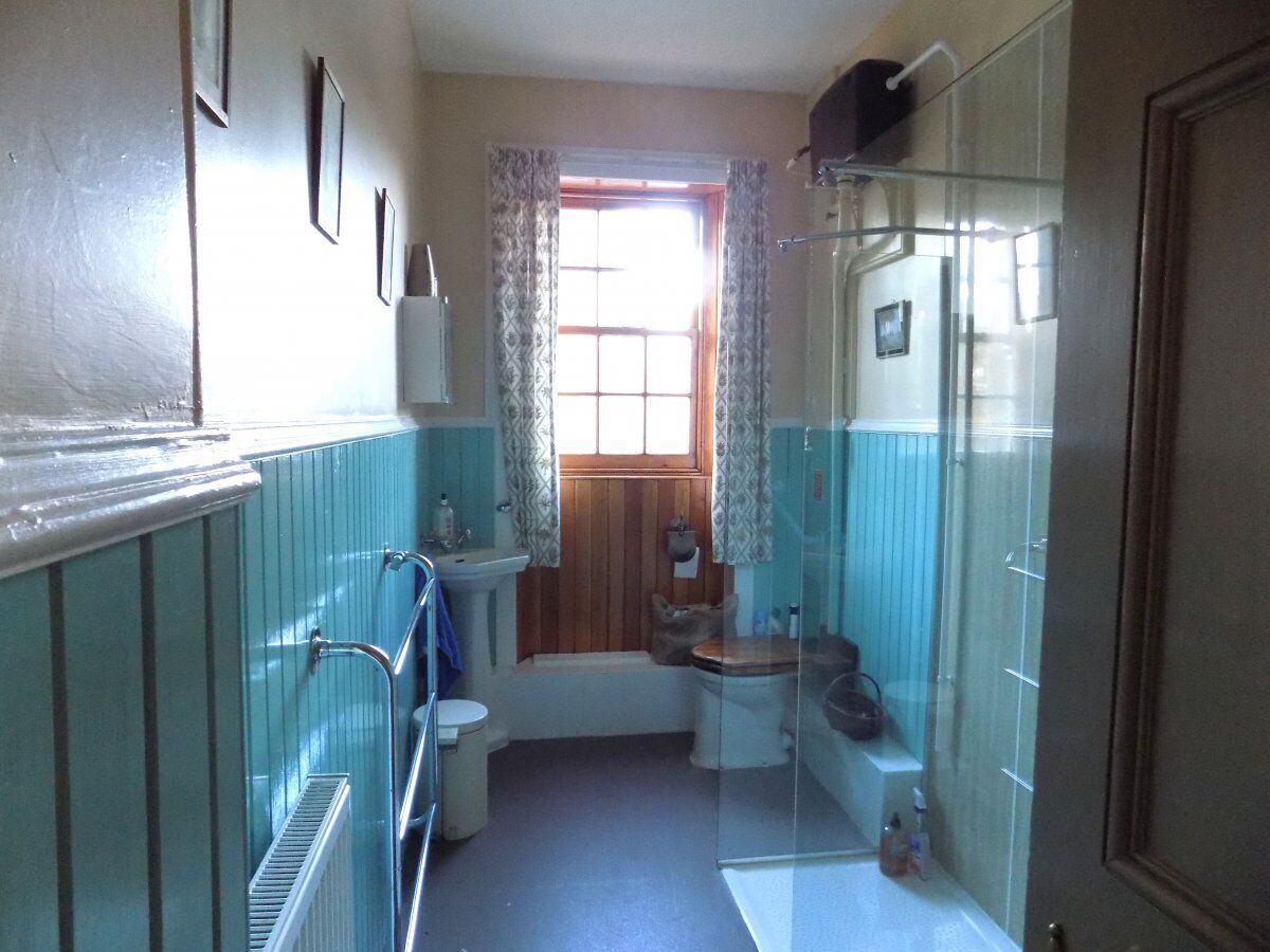 A compact bathroom with a toilet, sink, and shower area.
