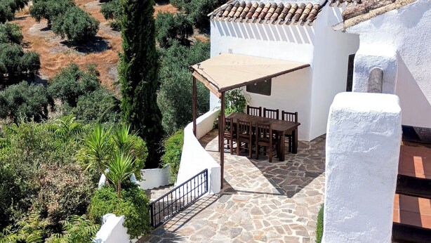 A terrace with stone flooring, a wooden table and chairs, and a view of olive groves. - Beautiful Farmhouse, Private Pool, Stunning Views Free Wifi, Historic Montefrio (Montefrio)
