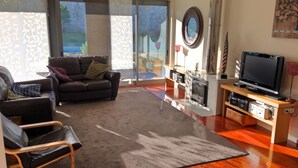 A modern living room with a sofa, a chair, a fireplace, and a television. - Elegant Villa, Caminha. Pool & large garden. Near market towns & beaches. (Caminha)