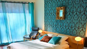 A neatly arranged bedroom with a bed, bedside lamps, a chair, and a decorative mirror on the wall. - Elegant Villa, Caminha. Pool & large garden. Near market towns & beaches. (Caminha)