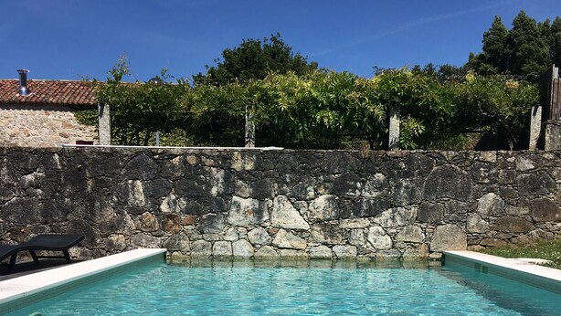 A clear swimming pool with stone walls and a tiled roof. - Elegant Villa, Caminha. Pool & large garden. Near market towns & beaches. (Caminha)