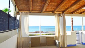 Ein Zimmer mit Holzboden, einer Couch, einem Tisch und Meerblick.