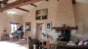 A spacious living room with a grand piano, a fireplace, and comfortable seating. - Secluded Perigordine Farmhouse in Monbazillac, Near Bergerac. Large Heated Pool. (Monbazillac)