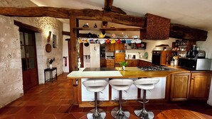 A kitchen with a central island, bar stools, wooden cabinets, and a variety of kitchenware. - Secluded Perigordine Farmhouse in Monbazillac, Near Bergerac. Large Heated Pool. (Monbazillac)
