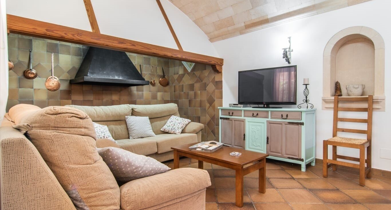 A cozy living room with a sofa, coffee table, and a television.