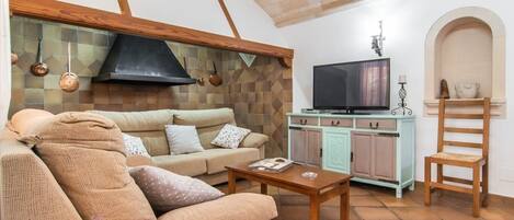 A cozy living room with a sofa, coffee table, and a television.