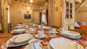 A dining area with wooden walls and a table set for a meal. - Renovated old farmhouse, chalet with decor that combines charm and tradition (Abondance)