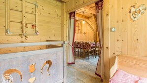 A wooden interior with a dining area, a mirror, and a heart-shaped decoration. - Renovated old farmhouse, chalet with decor that combines charm and tradition (Abondance)