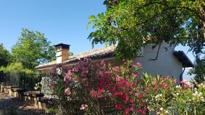 A rustic house with a tiled roof, surrounded by flowering plants and a gravel path. - Edge of Nature Reserve; a/c   5* views. Great peace & privacy. Mountains & Sea. (ATRI)