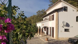 A two-story building with a white exterior, arched doorways, and a satellite dish. - Edge of Nature Reserve; a/c   5* views. Great peace & privacy. Mountains & Sea. (ATRI)