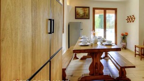 A dining area with a wooden table set for four, a refrigerator, and a vase with flowers on the right. - mansion - 8 rooms - 12/13 persons (Porto Vecchio)