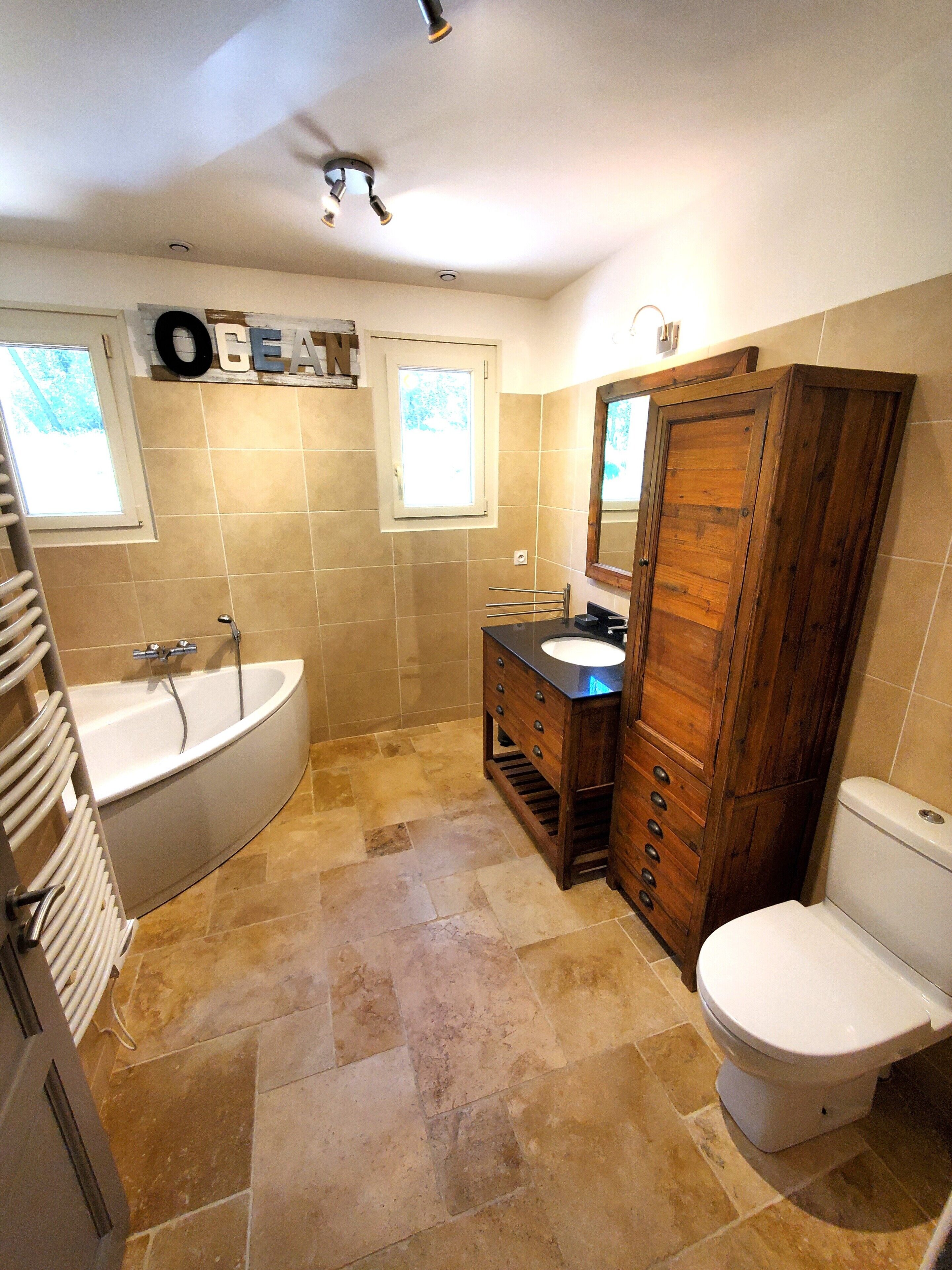 Ein Badezimmer mit Badewanne, Waschbecken, Waschtisch und Toilette.