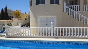 Un edificio de dos pisos con una piscina delantera.