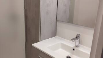 Bathtub, hair dryer, towels, toilet paper