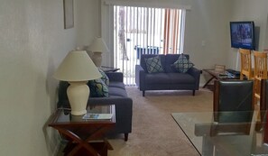 Una sala de estar con dos sofás, una mesa de centro y un televisor.