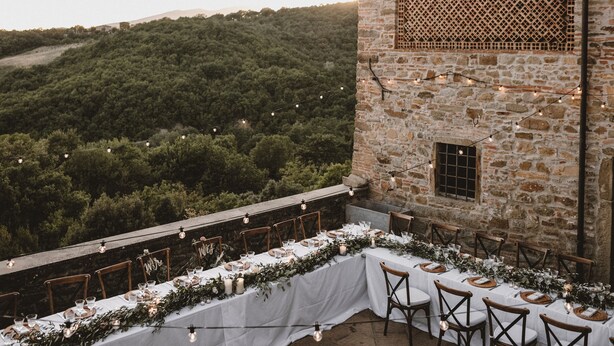 An outdoor dining area with stone walls, string lights, and a view of a forested hillside. - Villa Cungi with Privacy, stunning view, private pool, wifi Tuscany no neighbors (Sansepolcro)