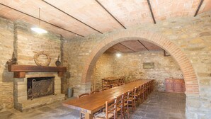 A long wooden table with chairs, a fireplace, stone walls, and an arched ceiling. - Villa Cungi with Privacy, stunning view, private pool, wifi Tuscany no neighbors (Sansepolcro)