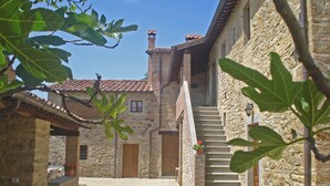 A stone building with a tiled roof, a staircase, and a small outdoor seating area with a table and chairs. - Villa Cungi with Privacy, stunning view, private pool, wifi Tuscany no neighbors (Sansepolcro)