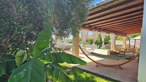 A hammock under a wooden pergola, a pool, and lush greenery. - BEAUTIFUL VILLA WITH PRIVATE POOL, 150 METERS FROM THE SEA (QUARTU SANT'ELENA ,CAPITANA)