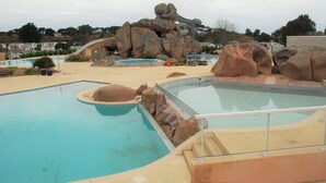 A swimming pool with rock formations and a slide.