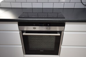 Een keuken met een inbouwoven en een kookplaat.