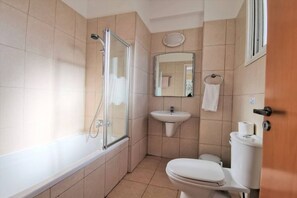 A bathroom with a bathtub, a shower, a sink, and a toilet.