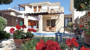 A modern house with a pool, outdoor seating, and potted plants. - 'Villa Xenia' HG 25  Play golf, tennis or relax in the spa (Aphrodite Hills)