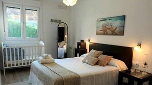 A bedroom with a large bed, bedside tables, a mirror, and a painting on the wall. - Villa with pool and fun Ría de Vigo (Muiño, O (Cobres))