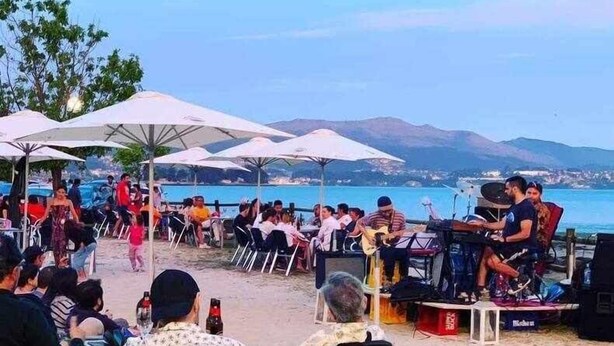 An outdoor seating area with tables and chairs, umbrellas, and a stage with musical equipment. - Villa with pool and fun Ría de Vigo (Muiño, O (Cobres))