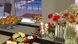 A table set with pastries, fruits, and flowers, with a view of outdoor seating. - Villa with pool and fun Ría de Vigo (Muiño, O (Cobres))