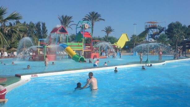 Ein Wasserpark mit verschiedenen Wasserspielbereichen und einem Schwimmbecken.