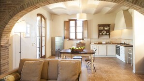A kitchen with an arched brick ceiling, a dining table with chairs, a refrigerator, and a sink. - Casa di Campagna Colline Senesi San Giovanni in Poggio - app. Twilight Siena (Monteroni d'Arbia)