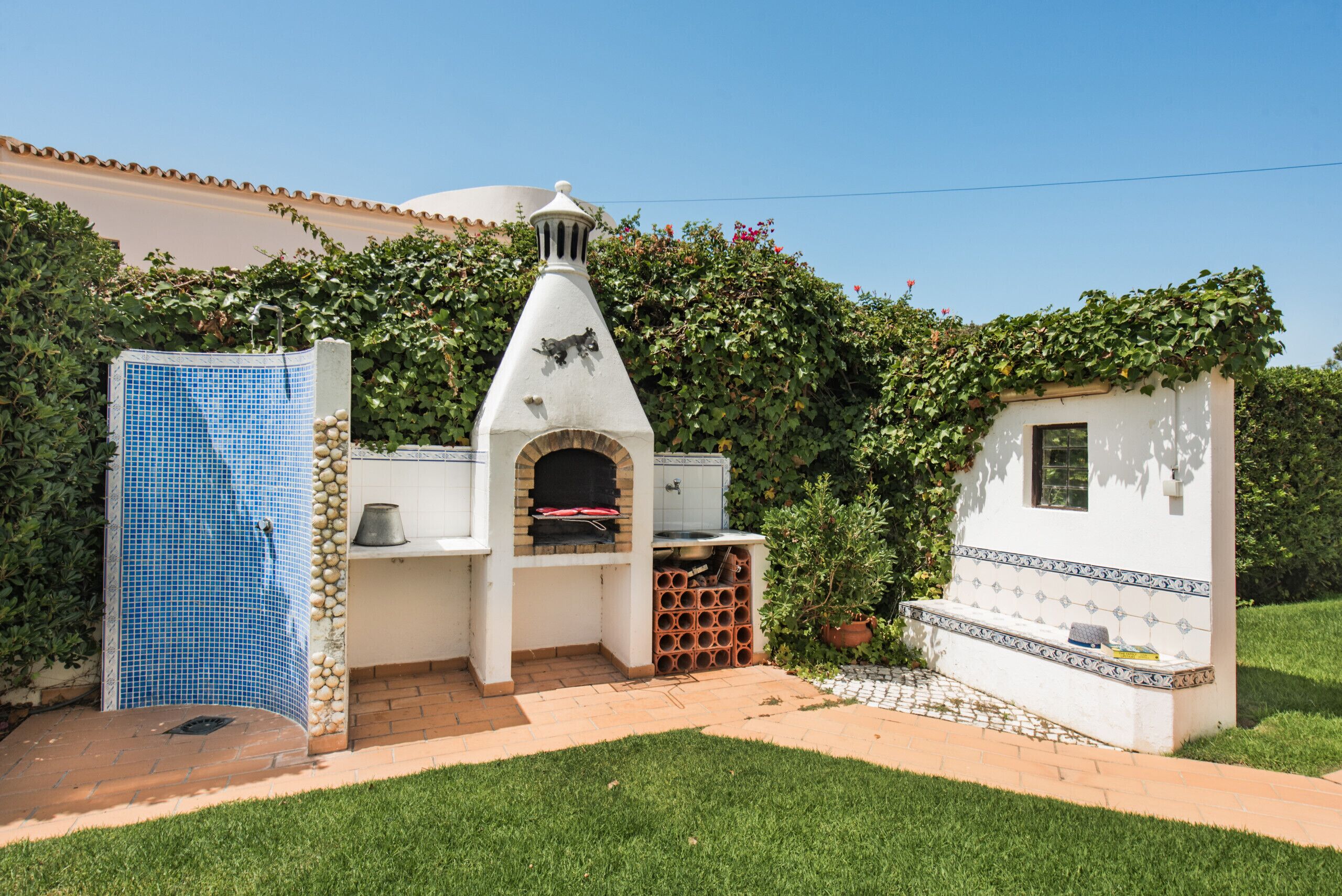 A patio area with a barbecue grill, a water feature, and a small seating area.