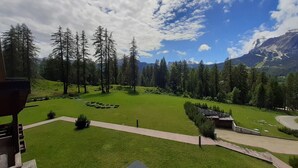 Un paysage verdoyant et luxuriant, avec un ciel dégagé, un sentier pavé de pierres et une vue sur des montagnes lointaines.