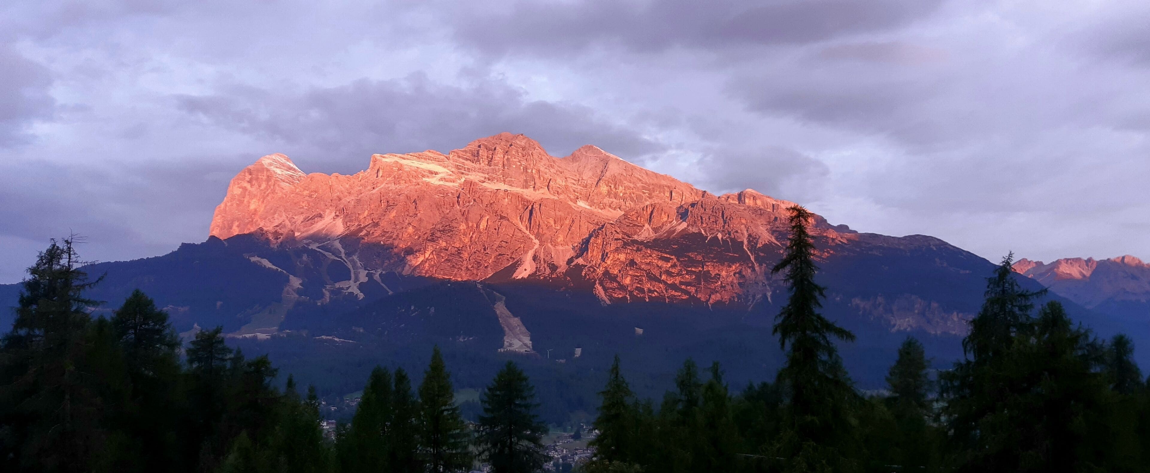 Une chaîne de montagnes avec un sommet imposant, entourée d’une forêt dense.